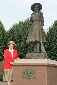 Bess Edwards, great grandniece of Annie Oakley, beside the Annie Oakley statue